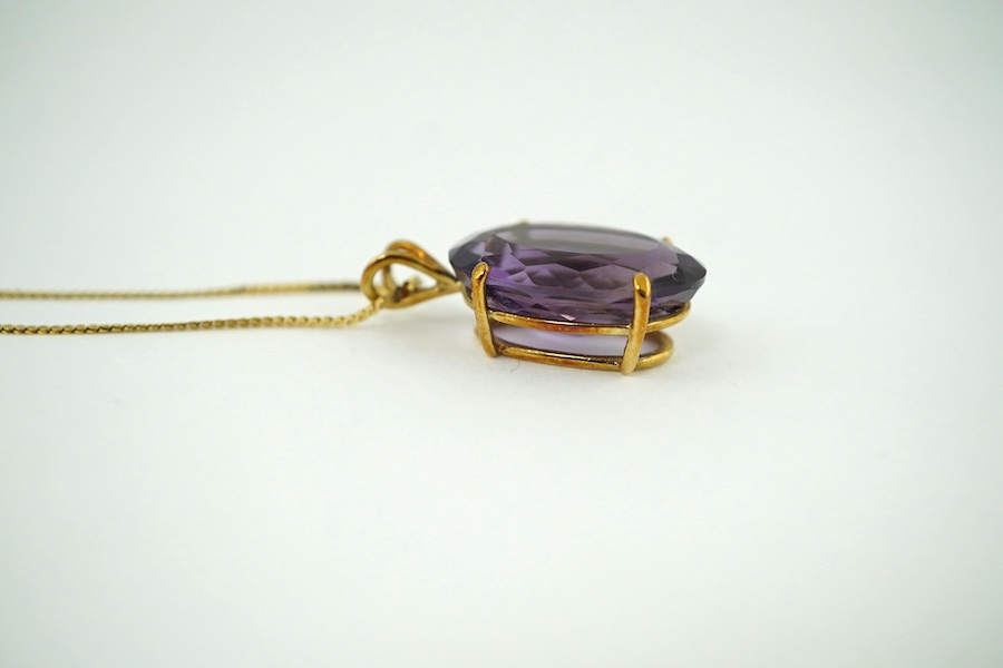 A yellow metal mounted oval facetted amethyst pendant, overall 27mm, on 14K gold flattened S link chain, gross weight 7 grams. Condition - good